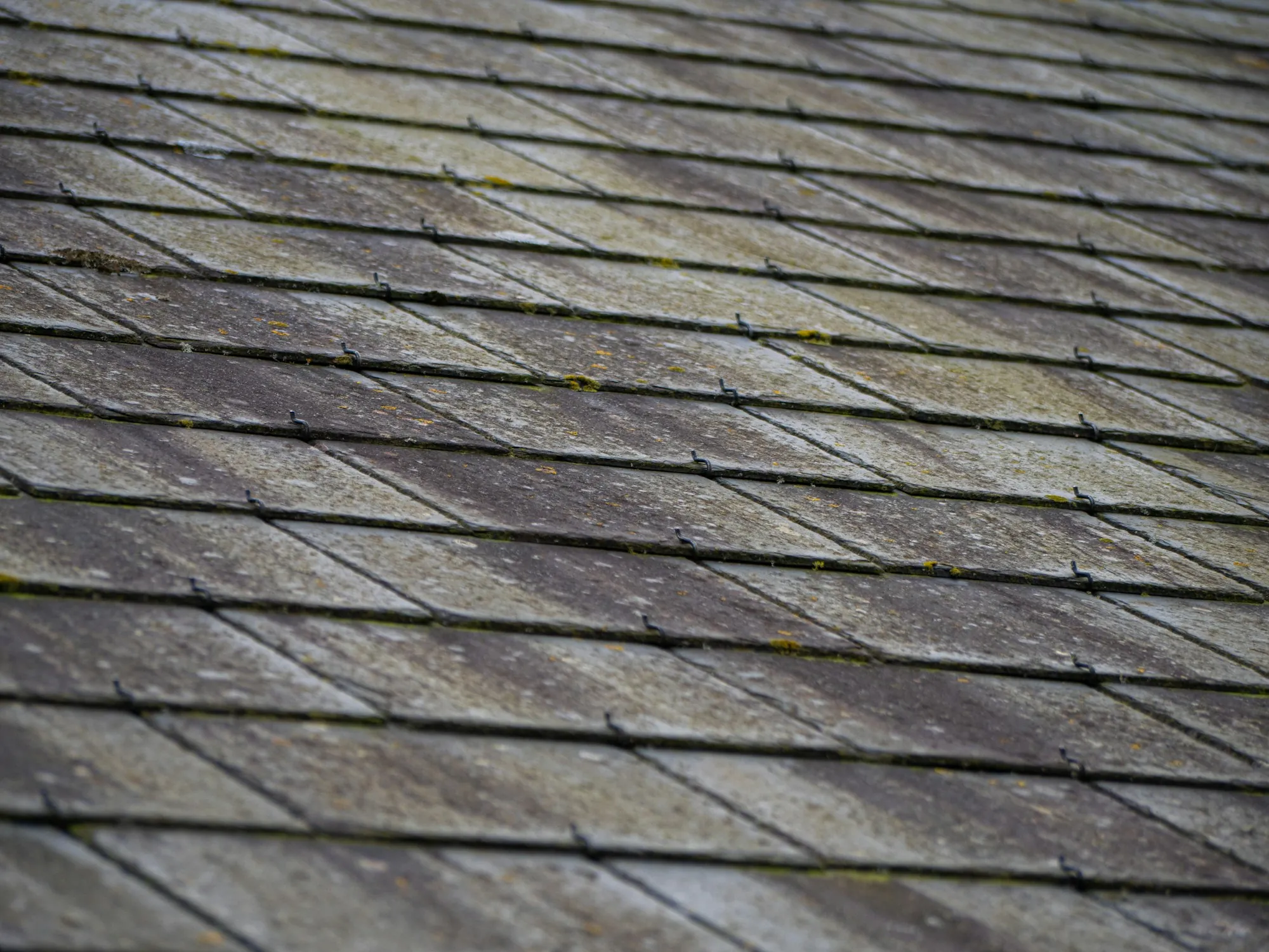 Close view of weathered shingle courses on a roof slope
