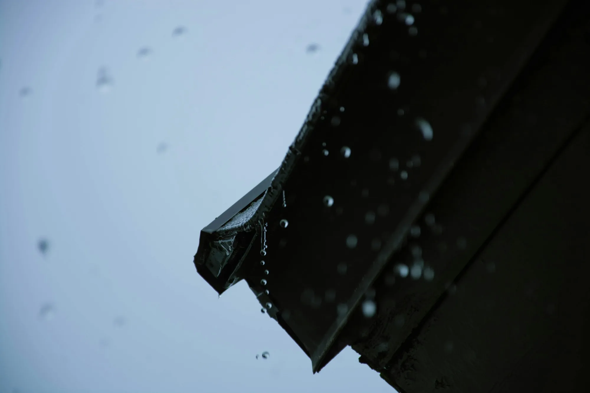 Roof edge against a pale sky during a storm